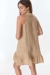 Vestido corto color ladrillo, sin mangas, con cuello camisero con volados, abotonado al frente y falda con volados.