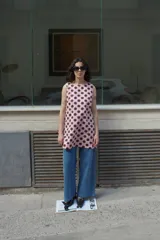 Vestido corto rosado con estampado de lunares marrones, corte en A y sin mangas.