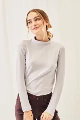 Polera negra de algodón y elastano, con cuello alto y mangas largas, corte ajustado al cuerpo.