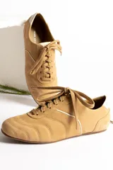 Zapatillas acordonadas color beige con detalles en blanco.