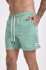 Short de baño color verde oliva con textura de rayas finas en relieve y cordón de ajuste blanco en la cintura.