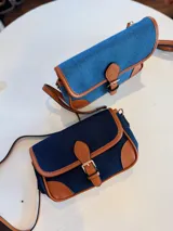 Cartera bandolera de jeans con detalles en cuero color marrón.