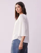 Blusa color blanco con escote en V y aplique de crochet.