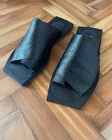 Sandalias negras de cuero vacuno, con base cuadrada y tira ancha sobre el empeine.