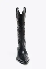 Bota de cuero negra estilo cowboy con bordados marrones, caña ancha, doble tirador y tacón medio.