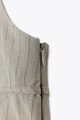 Top color gris con raya diplomática, de cuello halter ajustable y escote redondo. Espalda descubierta con tiras ajustables, forro interior y cierre lateral con cremallera oculta.
