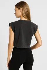 Remera cropped negra de algodón con cuello redondo y sisas amplias.