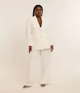 Blazer de poliéster color blanco, de corte sastrero, con cuello solapa, botón dorado redondo contrastante, manga larga con botón y bolsillos fake de solapa delanteros.