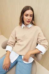 Sweater de punto fino color verde oliva, con calado delicado en hombros y mangas, cuello redondo y mangas largas.
