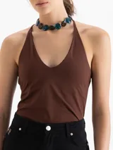 Top de punto color marrón, ajustado al cuerpo, con escote en V pronunciado y tirantes finos que se unen en la espalda.