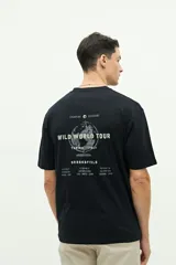 Remera negra de manga corta con estampado en la espalda de un globo terráqueo con el texto "Wild World Tour" y nombres de ciudades.