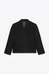 Blazer corta negra con cuello solapa, manga larga con hombreras, bolsillos delanteros y cierre cruzado con botones.