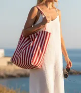Bolso tote de tela con rayas verticales rojas y blancas.