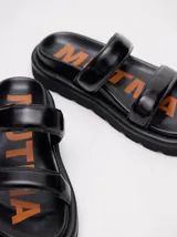 Sandalias blancas con doble tira ancha y plataforma negra.