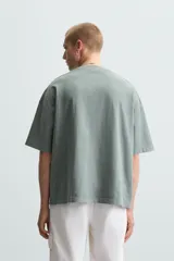 Camiseta de algodón de peso ligero, color verde musgo con efecto lavado, corte boxy fit y cuello redondo.