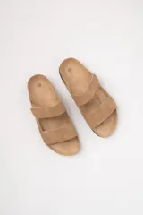 Sandalias planas color beige con dos tiras con velcro ajustables sobre el empeine y plantilla de corcho.