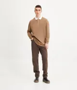 Remera polo de hombre color marrón, corte relaxed, confeccionada en media malla de algodón. Presenta cuello camisero blanco contrastante, tapeta con botones, mangas largas con sisa desplazada y puños ajustados.