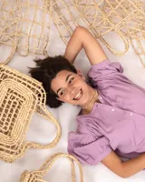 Bolso tipo canasto de fibras naturales color beige, con diseño calado.