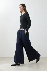 Pantalón de jean wide leg color azul oscuro con cintura alta y cinturón de cadena plateada.