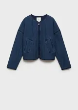 Chaqueta azul de estilo tejano vaquero con diseño acolchado y relleno. Tiene cuello redondo, cierre de cremallera frontal, dos bolsillos de ribete delanteros y mangas largas.