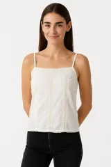 Musculosa blanca de algodón con breteles finos y escote cuadrado con detalle de puntilla.
