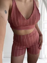 Conjunto de top y short color rosado con rayas verticales blancas. El top es tipo corpiño con breteles finos y el short es de tiro alto.
