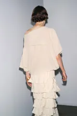 Falda midi color verde oliva confeccionada en tejido con viscosa. Presenta cintura elástica y detalle de volantes en el mismo tejido.