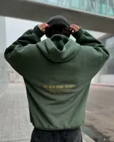 Hoodie verde militar de felpa con frisa gruesa, corte boxy y estampado en la espalda con la frase "BURN THE SHIPS. To fully commit to a course of action, with no possibility of retreat.".