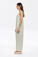 Mono largo color verde claro, de corte holgado, con breteles finos y bolsillos laterales.