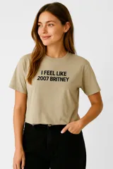 Remera color arena de algodón con cuello redondo y mangas cortas. Estampa frontal con la frase "I FEEL LIKE 2007 BRITNEY" en letras negras.