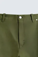 Pantalón cargo verde oliva de corte relaxed fit, confeccionado en tejido de algodón compacto con estructura twill. Cuenta con bolsillos frontales, traseros de vivo y bolsillos plastrón con solapa en las perneras.