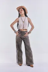 Pantalón de jean de corte ancho con estampado animal print y rayas blancas laterales.
