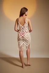 Vestido corto de crochet color crudo, con breteles finos y escote profundo.