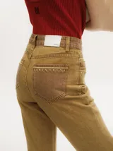 Pantalón de jean gris oscuro con corte oxford y apliques metálicos alrededor de los bolsillos y en la parte externa.