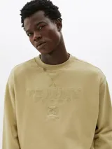 Buzo de cuello redondo color arena con logo Tommy Jeans bordado en relieve en el pecho y bandera bordada en el puño.