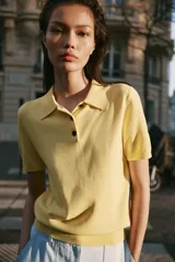 Top azul eléctrico de punto, con cuello polo, manga corta y cierre frontal con botones negros.