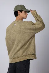 Buzo de friza color gris con cuello redondo y teñido artesanal, de corte oversize.