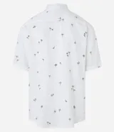 Camisa blanca de viscosa con estampado de cocoteros, corte relaxed, cuello inglés, manga corta y cierre abotonado.