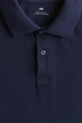Remera polo azul marino de piqué de algodón, corte regular, manga corta, cuello clásico y tapeta de botones.