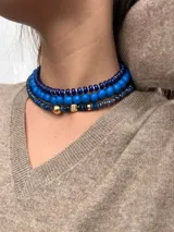 Collar corto de cuentas facetadas de color azul y detalles de cuentas doradas.