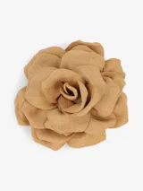 Broche decorativo en forma de flor de color tostado, confeccionado en tejido suave.