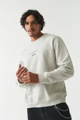 Buzo verde oliva de felpa con cuello redondo, puños y cintura acanalados. Estampado frontal con la frase "The Real Balance" en letras blancas y logo de la marca Mistral.