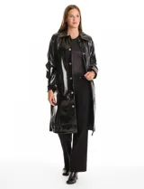 Chaqueta larga tipo trench de charol negro con acabado brillante e impermeable. Presenta cuello con solapa, cierre frontal con botones metálicos plateados y bolsillos laterales. Su diseño es de corte recto y estructura rígida.