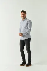 Camisa de hombre a rayas verticales celestes y blancas, corte slim fit, manga larga, logo bordado en el pecho y cartera con botones.