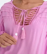 Blusa tipo blusón color rosado, de viscosa, con cuello redondo, manga larga acampanada, pliegues en los hombros, detalle de entredós en el escote y tiras de ajuste con borla.