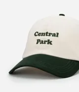 Gorra de béisbol bicolor, con cuerpo blanco y visera verde oscuro. Tiene bordado el texto "Central Park" en verde.
