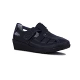 Zapato guillermina negro de cuero sintético, con punta cerrada, aberturas laterales, ajuste con velcro y suela de goma con plataforma baja.