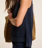Musculosa en piquet color verde oliva, con escote en pico, breteles anchos, pequeñas aberturas laterales y bajos con pespuntes.