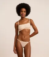 Soutien sin copa con aro, confeccionado en encaje floral color blanco. Presenta tirantes finos regulables y removibles, y cierre trasero con gancho.