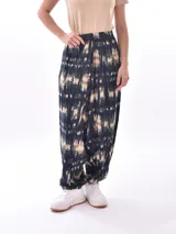 Pantalón babucha con estampado abstracto en tonos azul, beige y verde.
